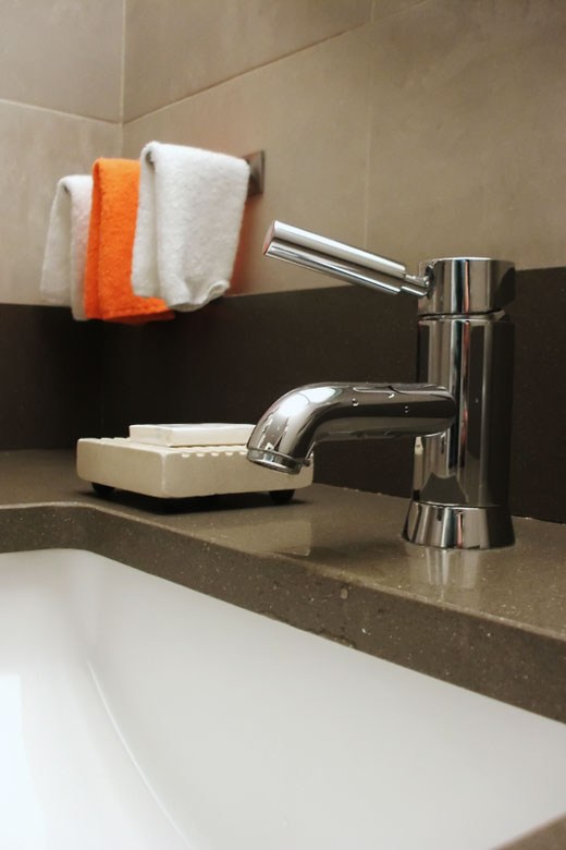 concrete bathroom counter top with undermount sink and chrome faucet